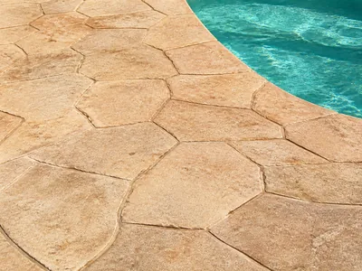 Detalle del relieve de hormigón impreso en un suelo exterior húmedo junto a piscina