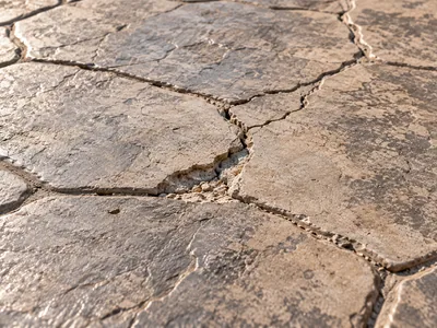 Detalle realista de una fisura en hormigón impreso con textura de piedra y marcas de inspección